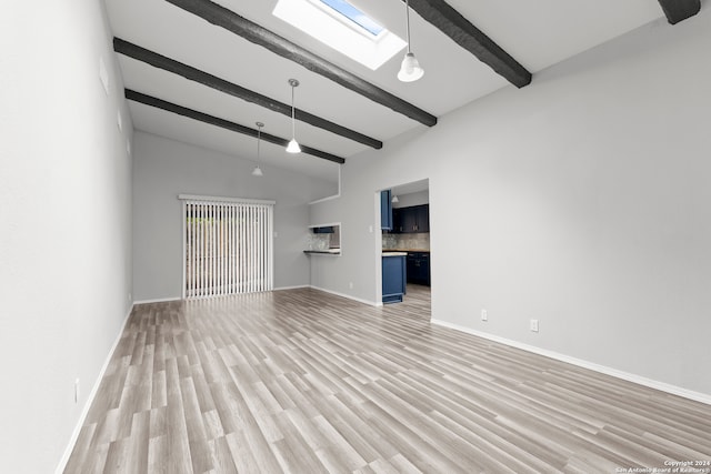 unfurnished living room with vaulted ceiling with skylight and light wood-type flooring