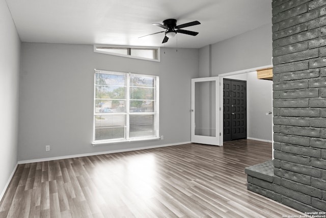 unfurnished living room with french doors, hardwood / wood-style flooring, vaulted ceiling, and ceiling fan