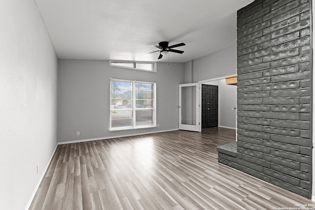 unfurnished living room featuring ceiling fan, light hardwood / wood-style floors, french doors, and vaulted ceiling