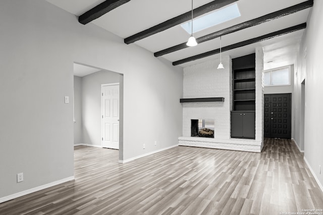 unfurnished living room with beam ceiling, hardwood / wood-style floors, high vaulted ceiling, and a brick fireplace