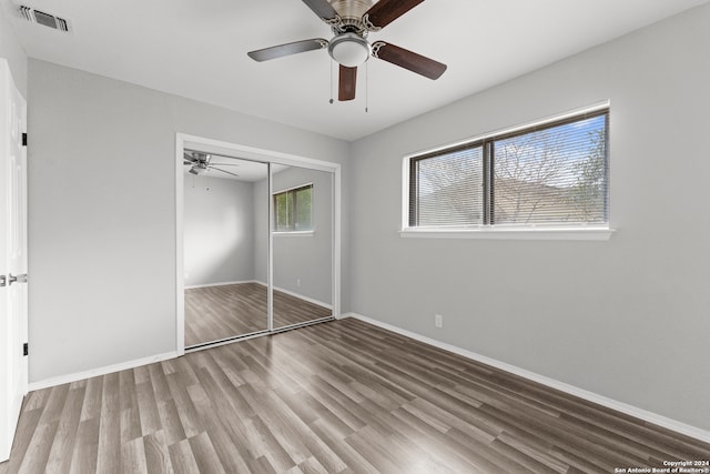 unfurnished bedroom with light hardwood / wood-style flooring, a closet, and ceiling fan