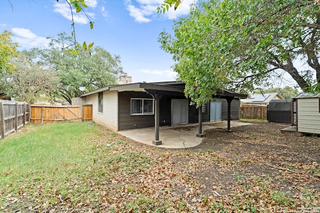 rear view of house with a storage shed and a patio