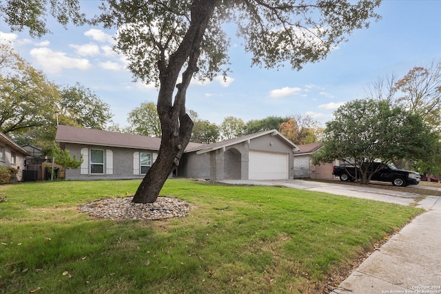 ranch-style home featuring cooling unit, a garage, and a front lawn