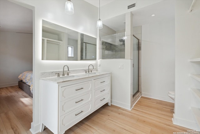 bathroom featuring vanity, hardwood / wood-style flooring, toilet, and an enclosed shower