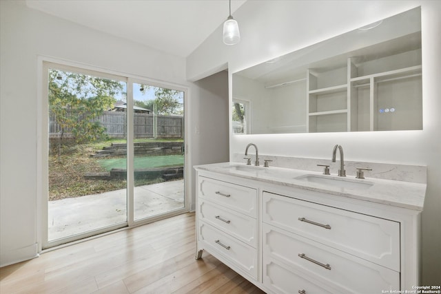 bathroom with vanity, vaulted ceiling, and hardwood / wood-style flooring