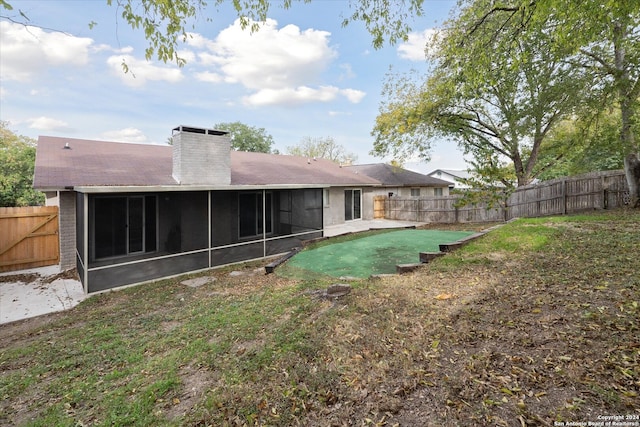 back of house with a sunroom and a yard