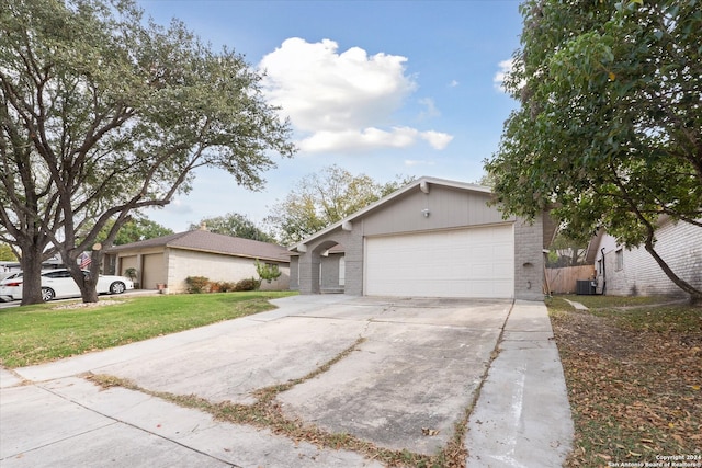 ranch-style home featuring a front yard, central AC, and a garage