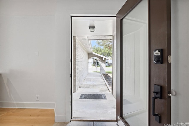 entryway with hardwood / wood-style flooring and brick wall