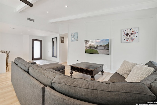 living room featuring beamed ceiling and light hardwood / wood-style flooring