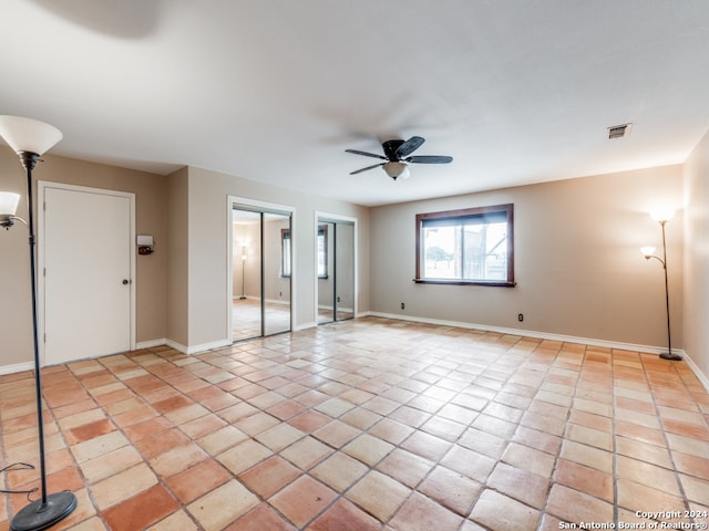 tiled spare room with ceiling fan