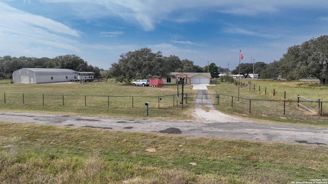 view of yard with a garage and a rural view