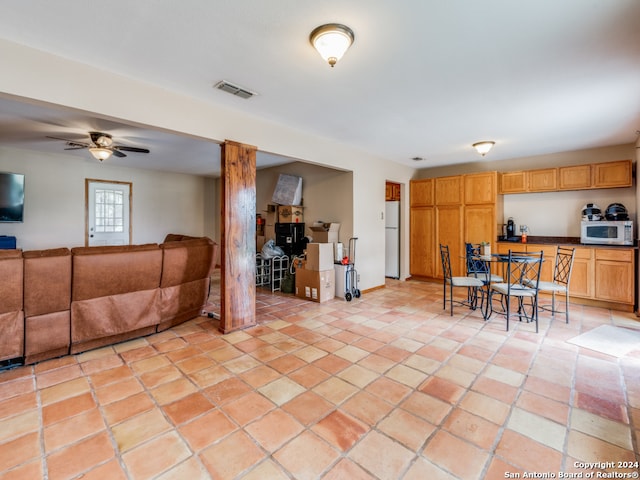 interior space with ceiling fan, white appliances, and light tile patterned floors