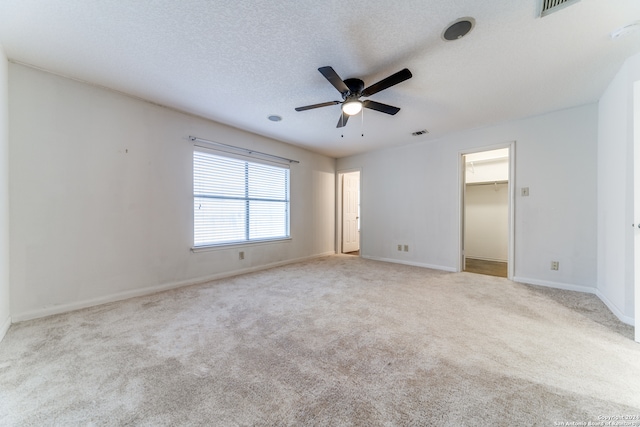 carpeted empty room with ceiling fan and a textured ceiling