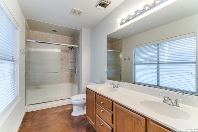 bathroom with vanity, a shower with door, toilet, a textured ceiling, and concrete flooring