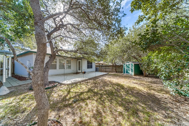 view of yard featuring a storage unit and a patio