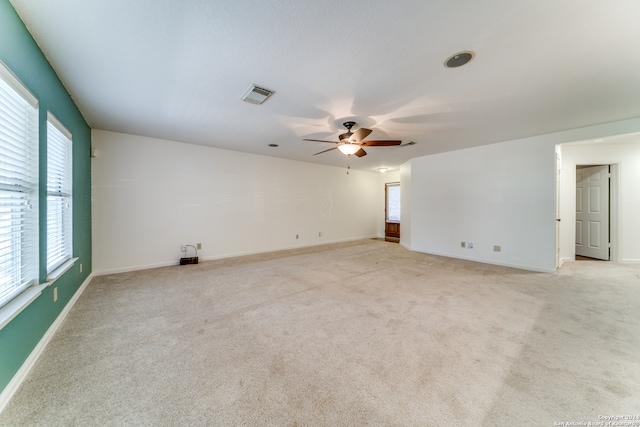 carpeted spare room featuring ceiling fan