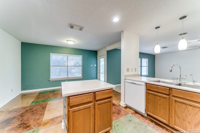 kitchen with dishwasher, sink, a textured ceiling, decorative light fixtures, and a kitchen island