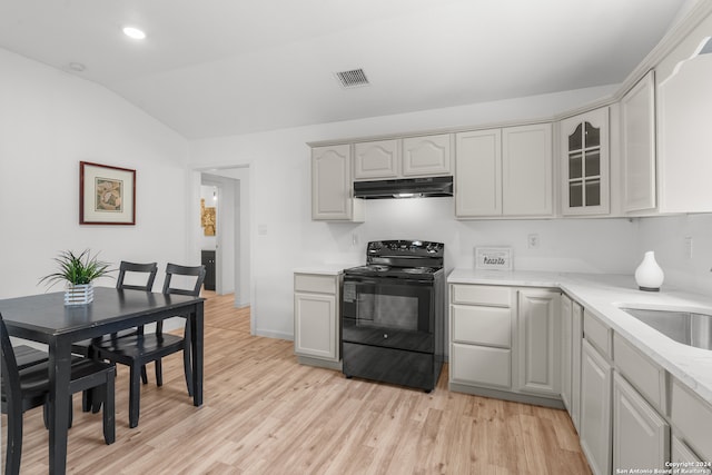 kitchen with black range with electric stovetop, sink, vaulted ceiling, and light wood-type flooring