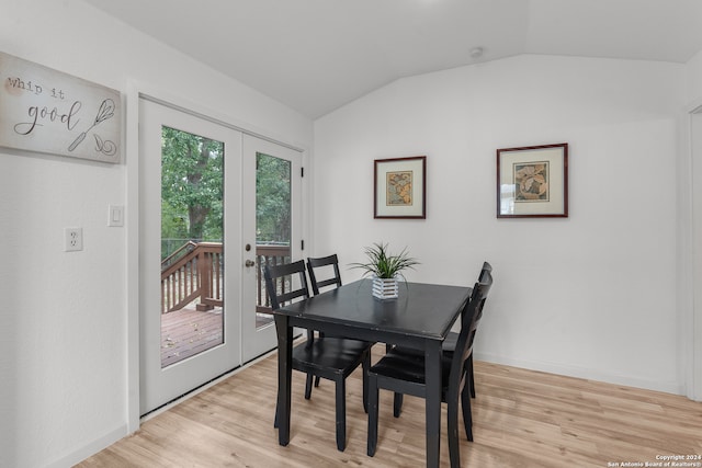 dining area featuring lofted ceiling, light wood-type flooring, and french doors