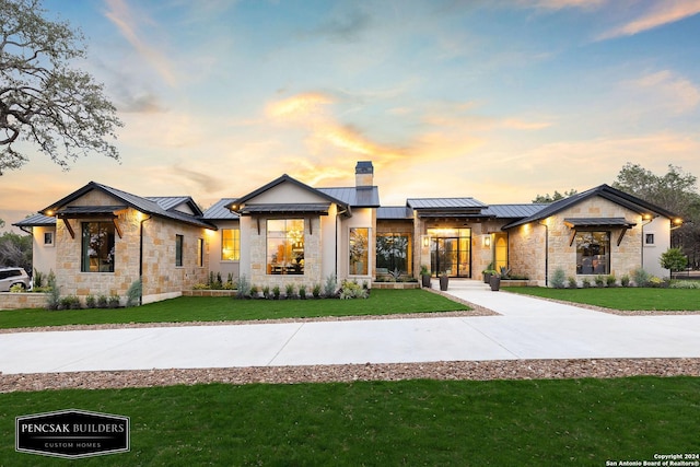 view of front of home with a lawn and solar panels