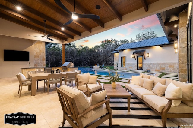 patio terrace at dusk with outdoor lounge area, ceiling fan, an outbuilding, and grilling area