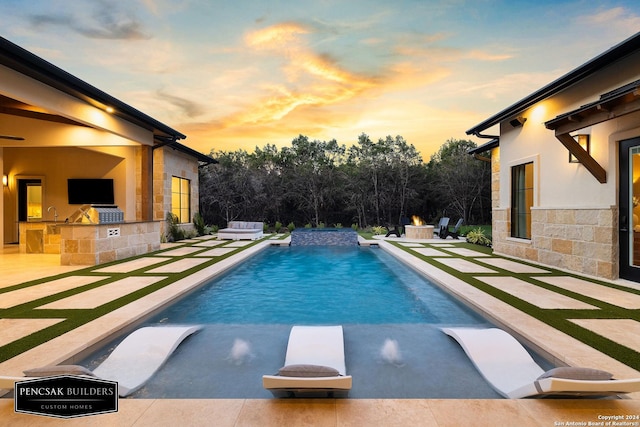 view of pool featuring an outdoor kitchen and a patio area