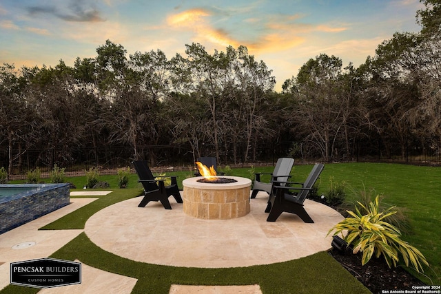 patio terrace at dusk with a yard and a fire pit