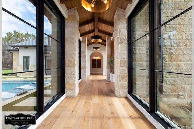 hall featuring hardwood / wood-style floors and lofted ceiling with beams