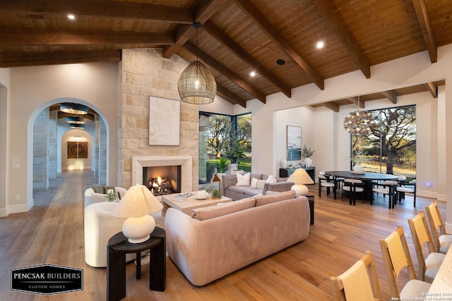 living room featuring a healthy amount of sunlight, wood-type flooring, a fireplace, and wooden ceiling