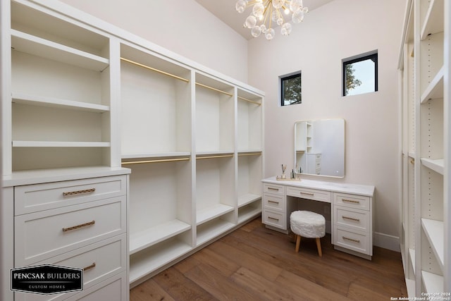 spacious closet featuring dark hardwood / wood-style flooring and a chandelier