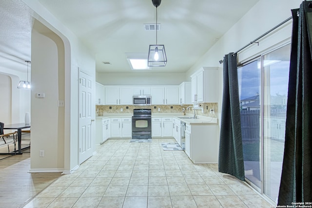 kitchen with white cabinets, appliances with stainless steel finishes, decorative light fixtures, and tasteful backsplash