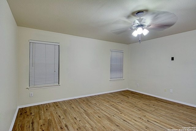 spare room featuring a textured ceiling, light hardwood / wood-style floors, and ceiling fan