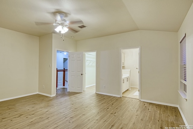 unfurnished bedroom with a spacious closet, ceiling fan, light hardwood / wood-style flooring, ensuite bathroom, and a closet