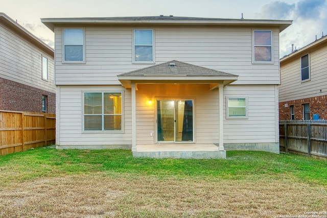 rear view of house with a patio and a lawn