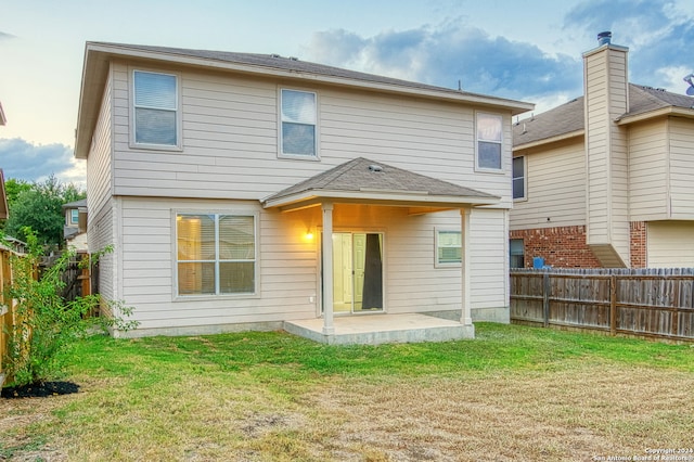 back of property with a patio area and a lawn