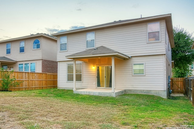 back of house featuring a patio area and a lawn