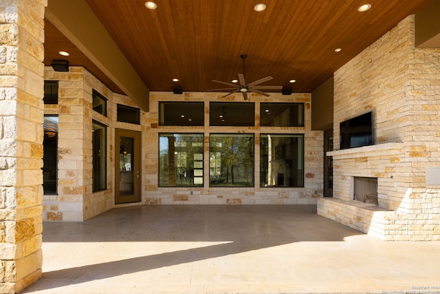 entrance to property with ceiling fan and an outdoor stone fireplace