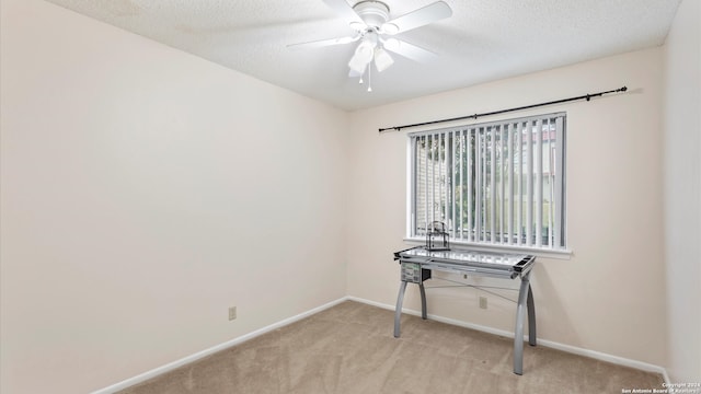 carpeted empty room featuring ceiling fan and a textured ceiling