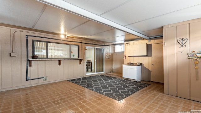 clothes washing area featuring wooden walls