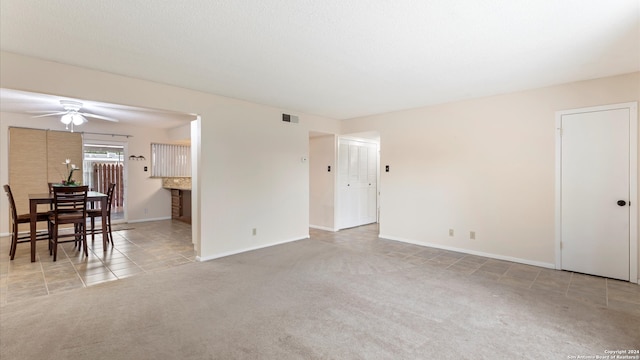 spare room with ceiling fan and light carpet