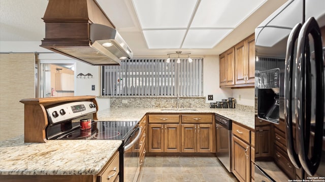 kitchen with light stone countertops, sink, premium range hood, and stainless steel appliances