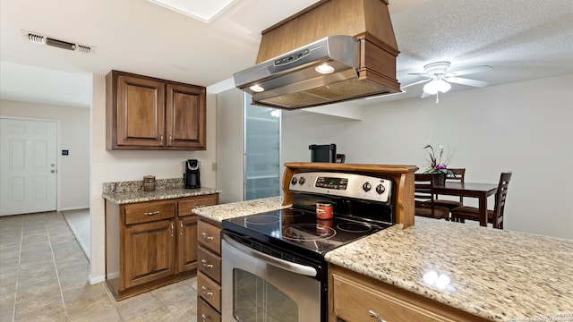 kitchen featuring ventilation hood, electric range, ceiling fan, light stone countertops, and a textured ceiling