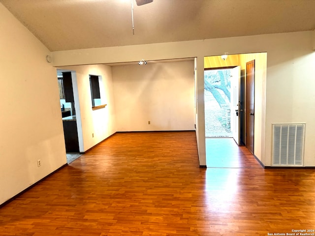 empty room with hardwood / wood-style flooring, ceiling fan, and lofted ceiling