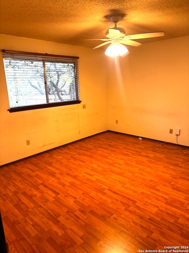 spare room featuring plenty of natural light, light hardwood / wood-style floors, and a textured ceiling