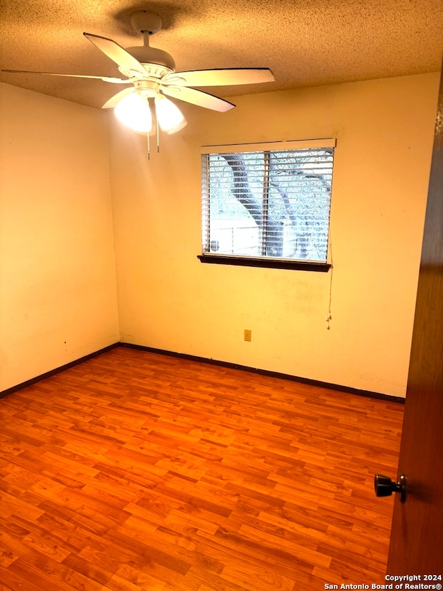 unfurnished room featuring ceiling fan, light hardwood / wood-style flooring, and a textured ceiling