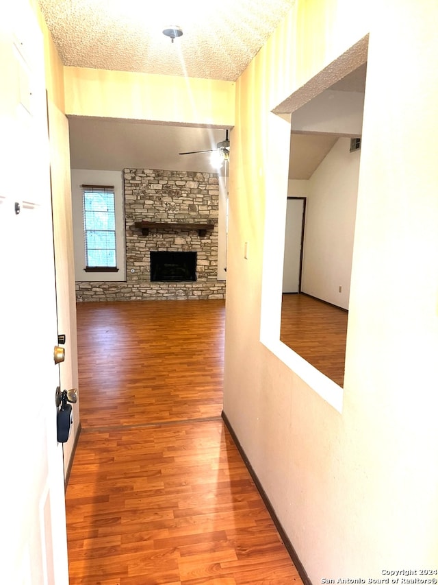 hall featuring wood-type flooring and a textured ceiling