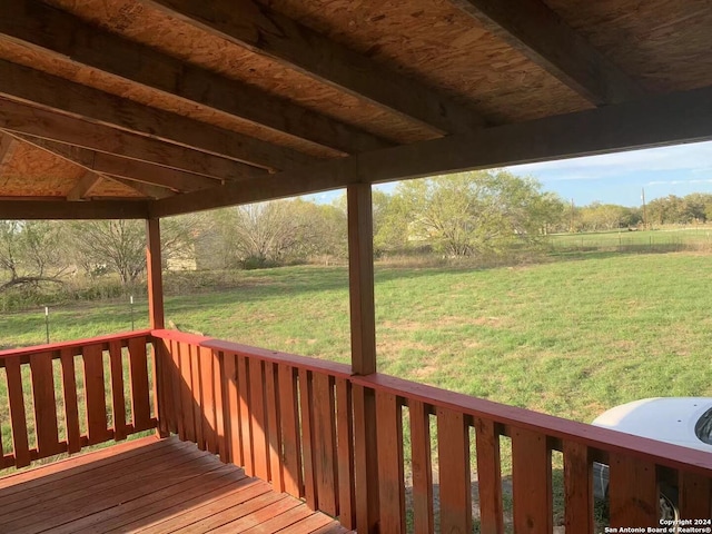 wooden deck with a yard and a rural view