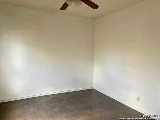 unfurnished room featuring ceiling fan and dark parquet flooring