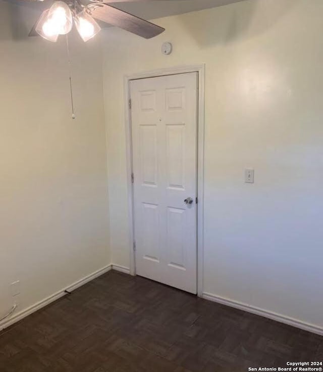 empty room with dark parquet flooring and ceiling fan