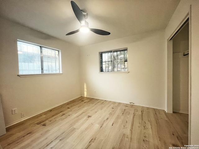 unfurnished bedroom with multiple windows, ceiling fan, and light hardwood / wood-style flooring